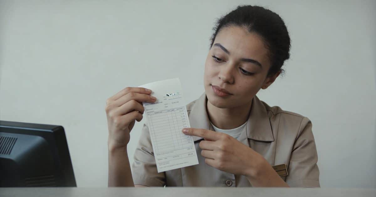 employe de caisse verifiant sa fiche de paie