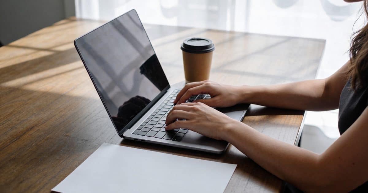 femme assise a un bureau ecrivant un email
