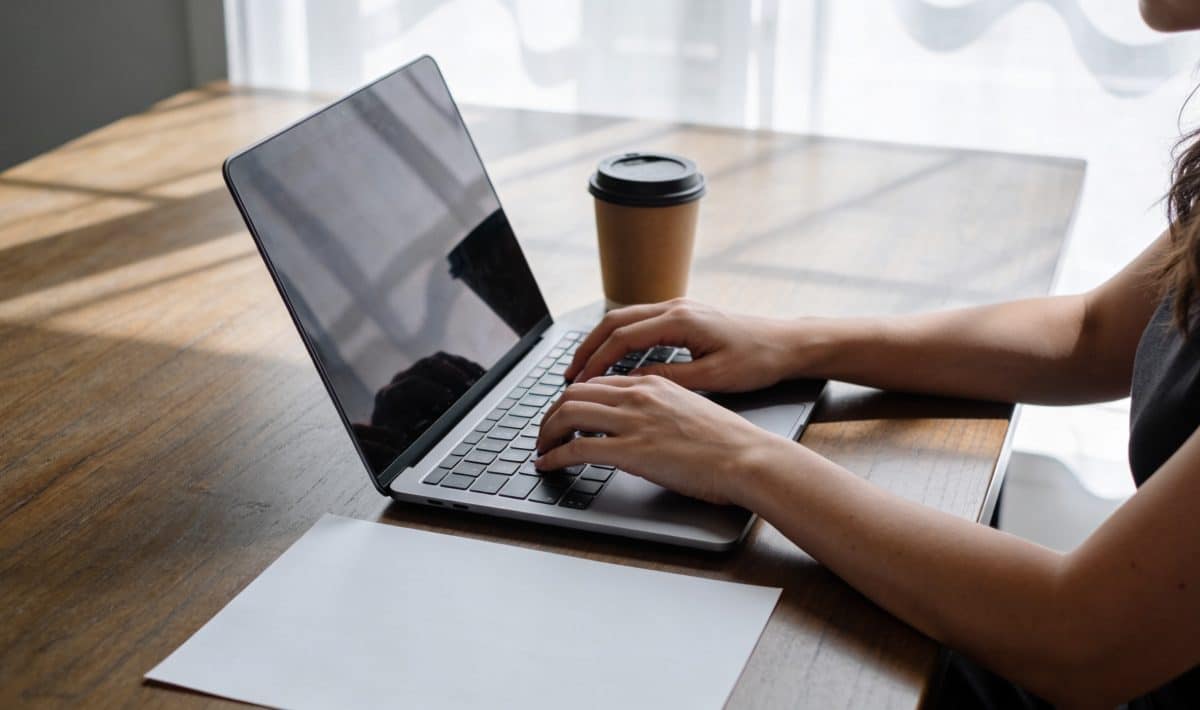 femme assise a un bureau ecrivant un email