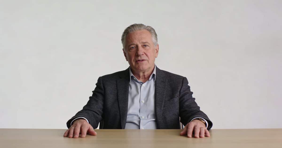 Homme de 55 ans assis seul devant bureau