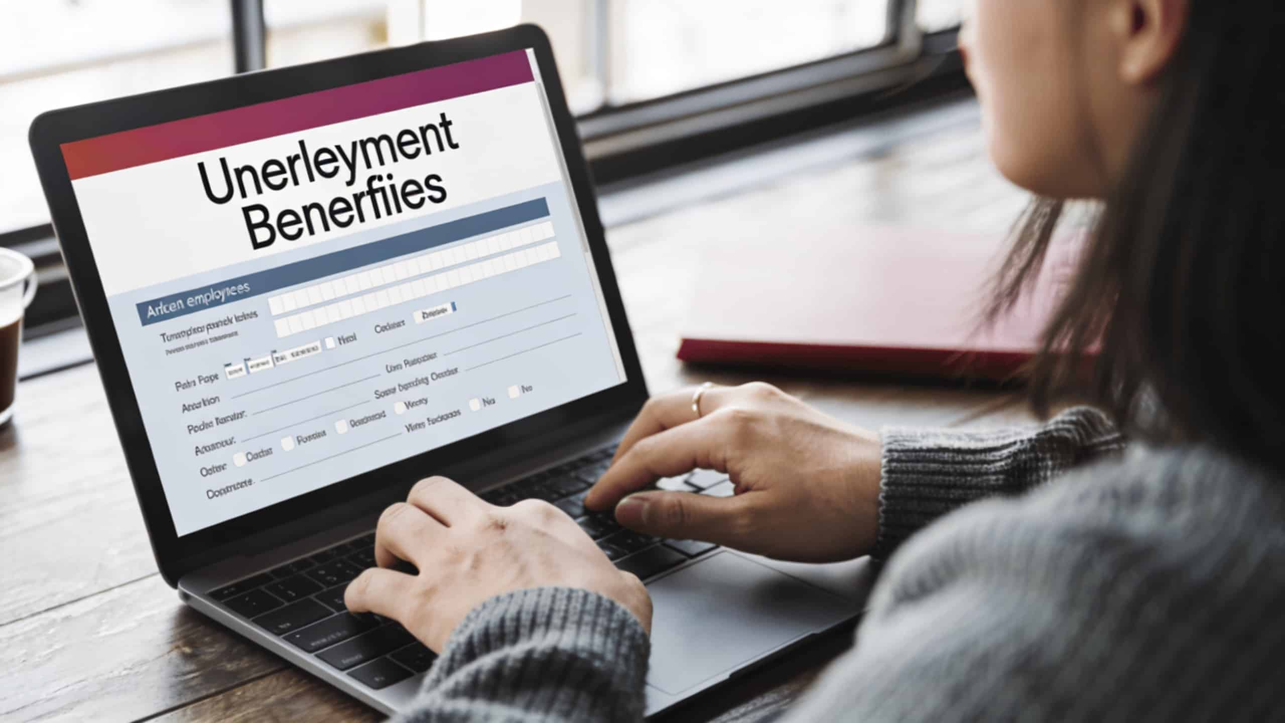 jeune employe assis devant ordinateur consultant allocation chomage