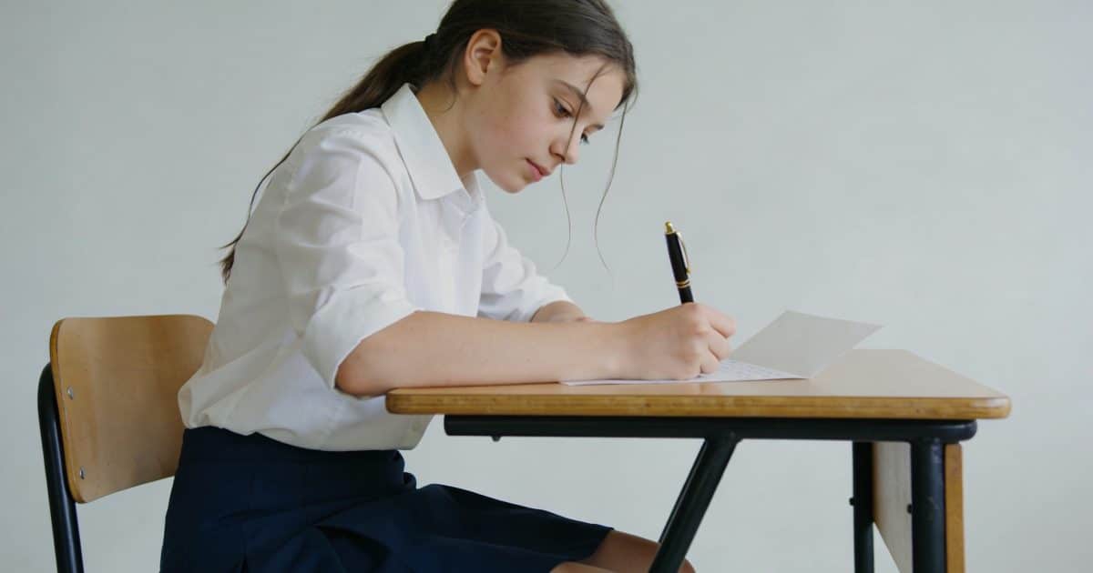 Lyceenne assise bureau ecrit lettre a la main
