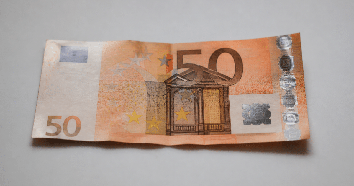 billet de cinquante euros pose a plat sur surface blanche
