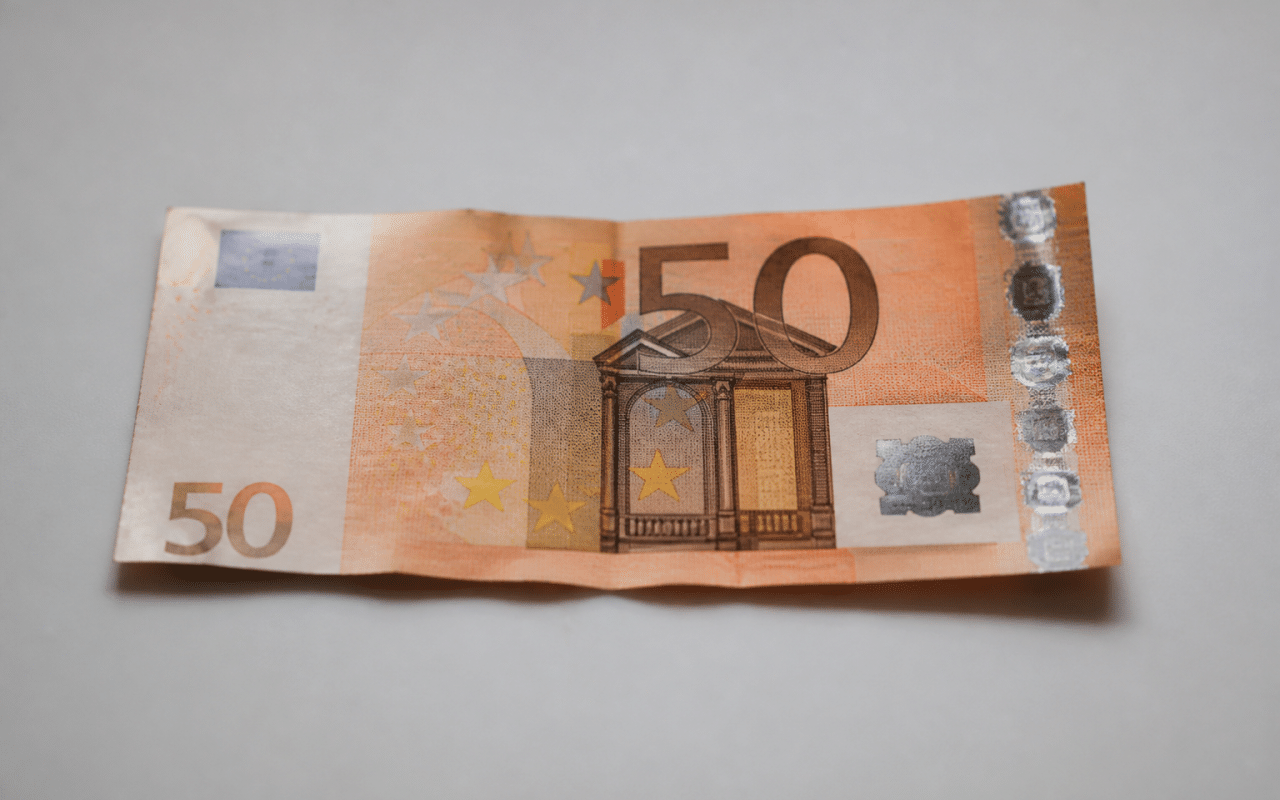 billet de cinquante euros pose a plat sur surface blanche