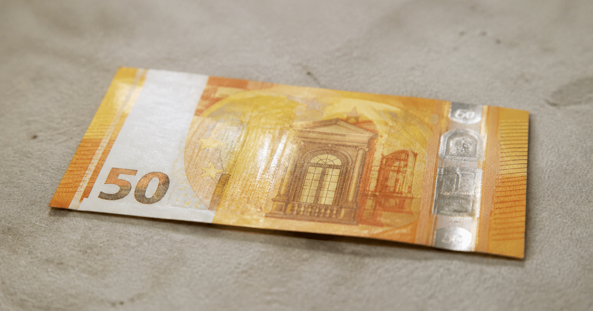 Billet de cinquante euros jaune posé à plat sur surface