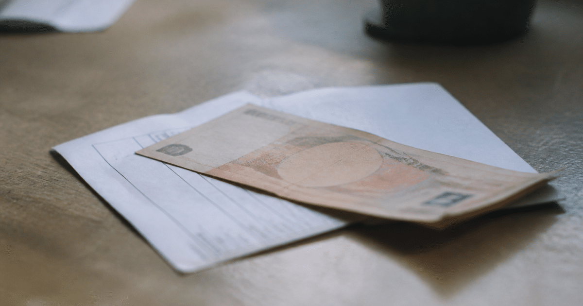 Billet de banque posé sur relevé de compte bancaire.