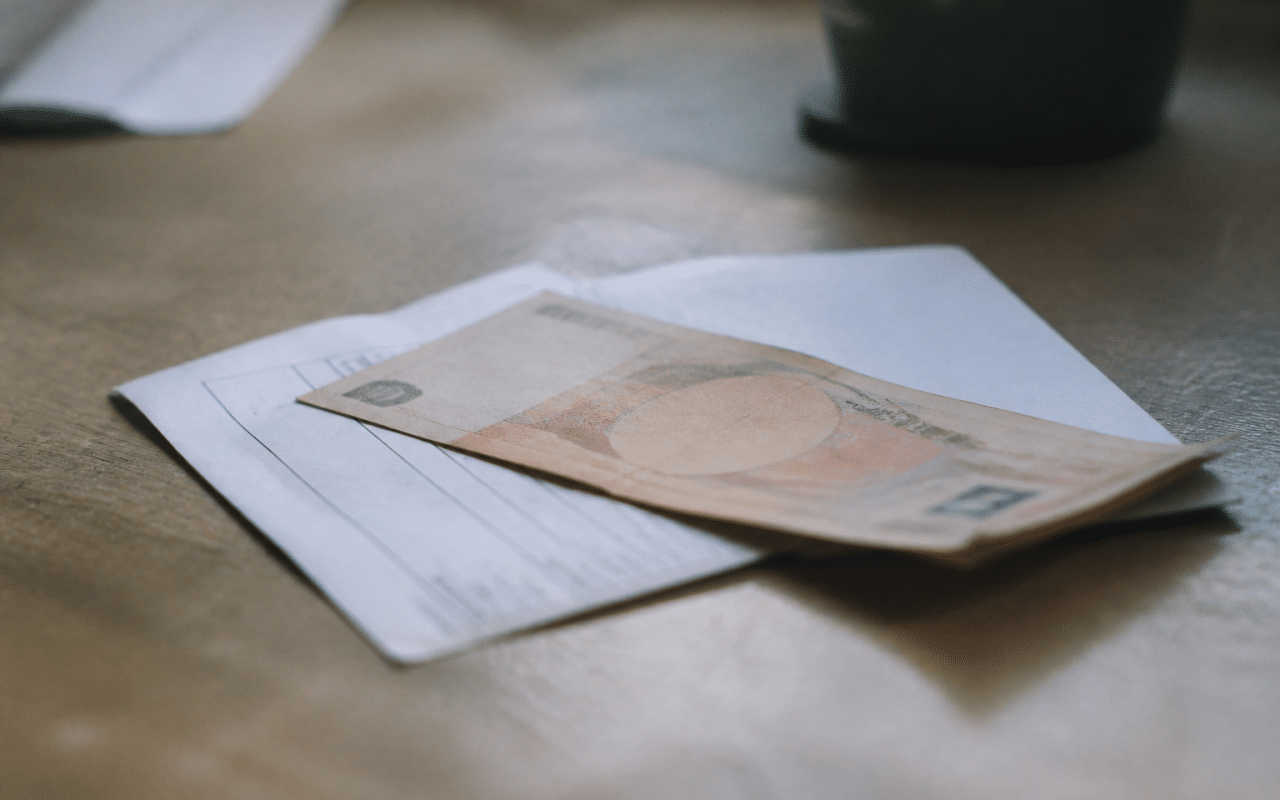 Billet de banque posé sur relevé de compte bancaire.