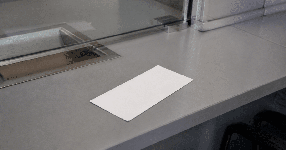 Cheque papier blanc posé sur bureau bancaire gris.