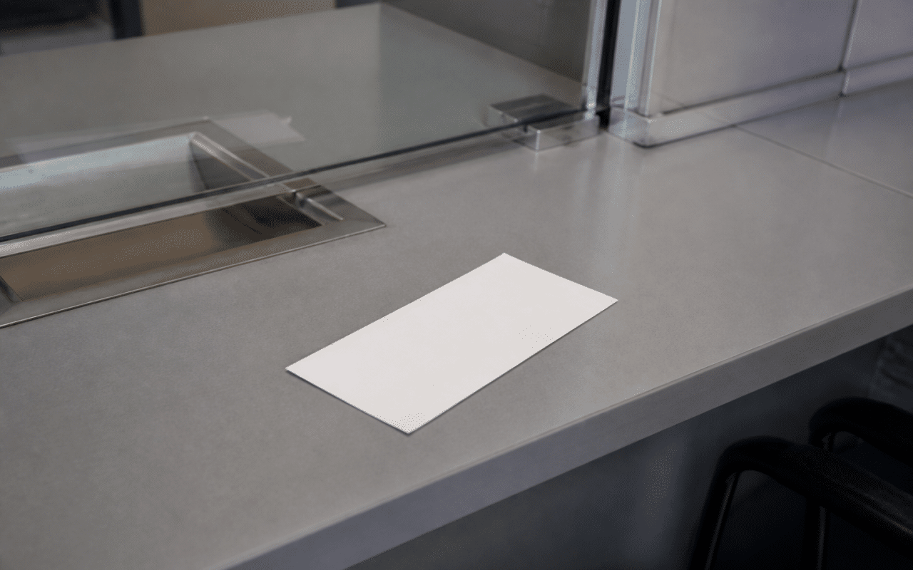 Cheque papier blanc posé sur bureau bancaire gris.