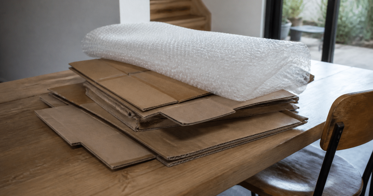 Cartons et papier bulle empiles sur table de travail domestique