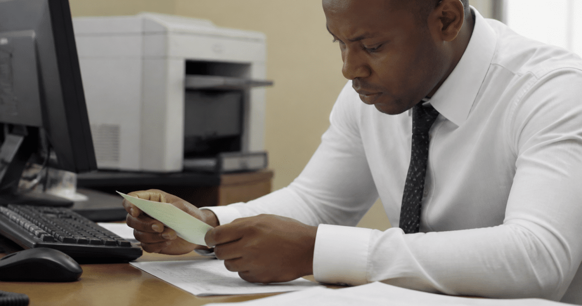 Employe bancaire verifiant cheque sur son bureau avec documents