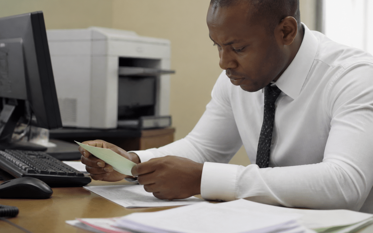 Employe bancaire verifiant cheque sur son bureau avec documents
