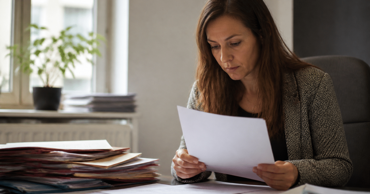 Femme consultant documents administratifs à son bureau.