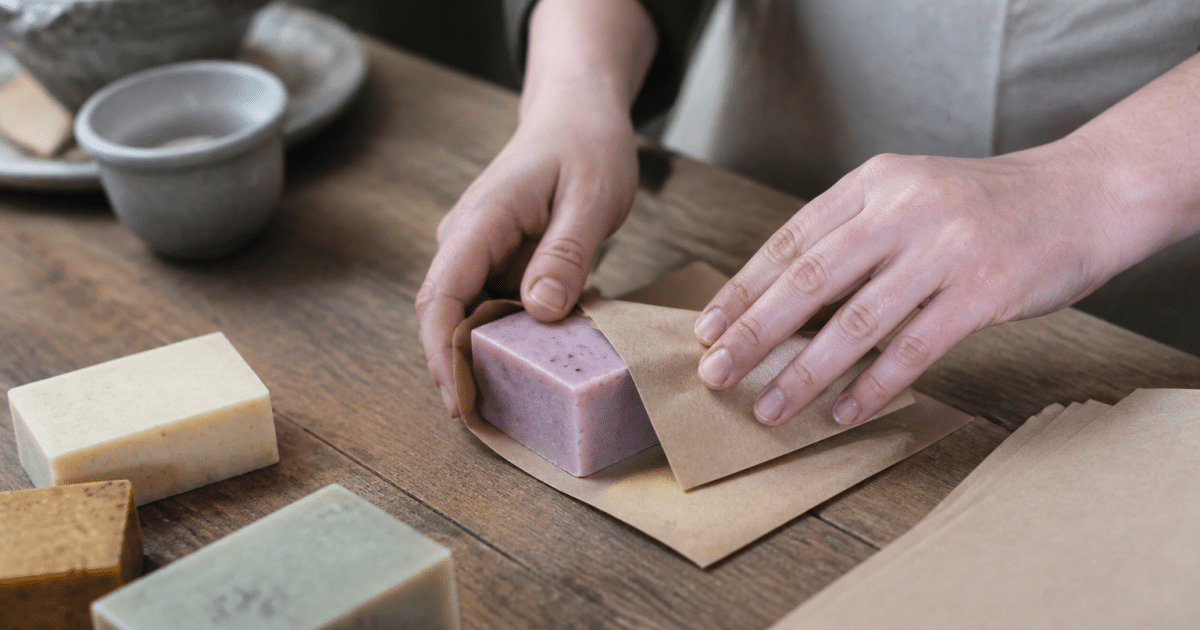Mains pliant papier kraft autour barres savon colorées