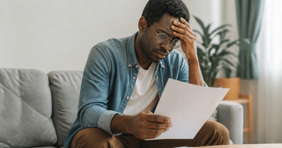 Travailleur assis tenant des documents administratifs inquiet
