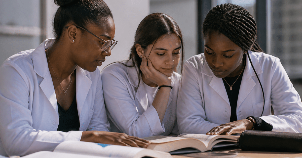 Etudiants en blouse blanche consultant livres medicaux ensemble.