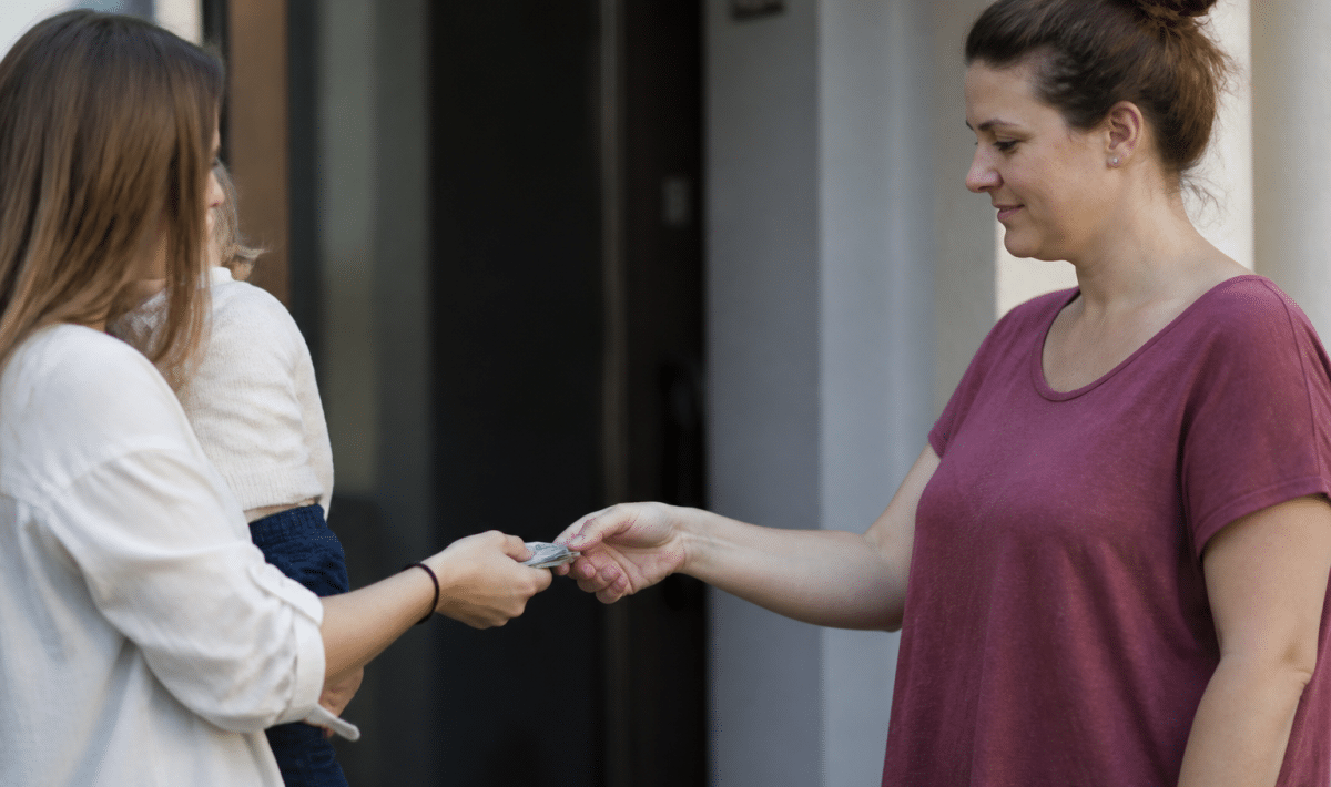 Parent remettant argent liquide a gardienne d'enfants