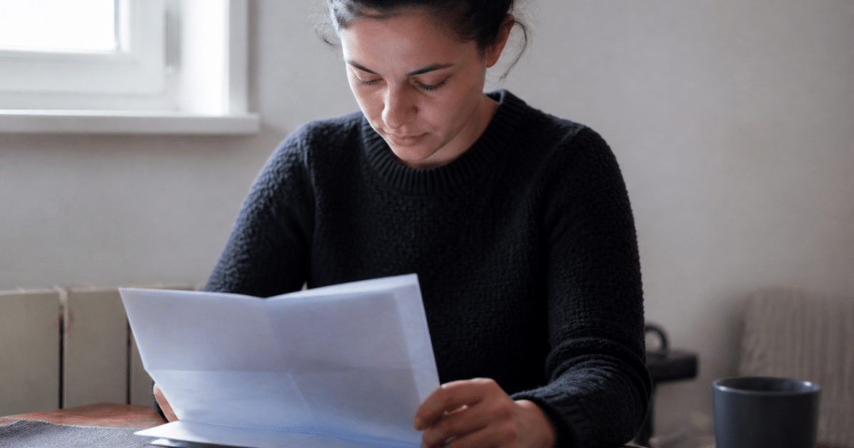 Personne consultant document administratif CAF sur table.