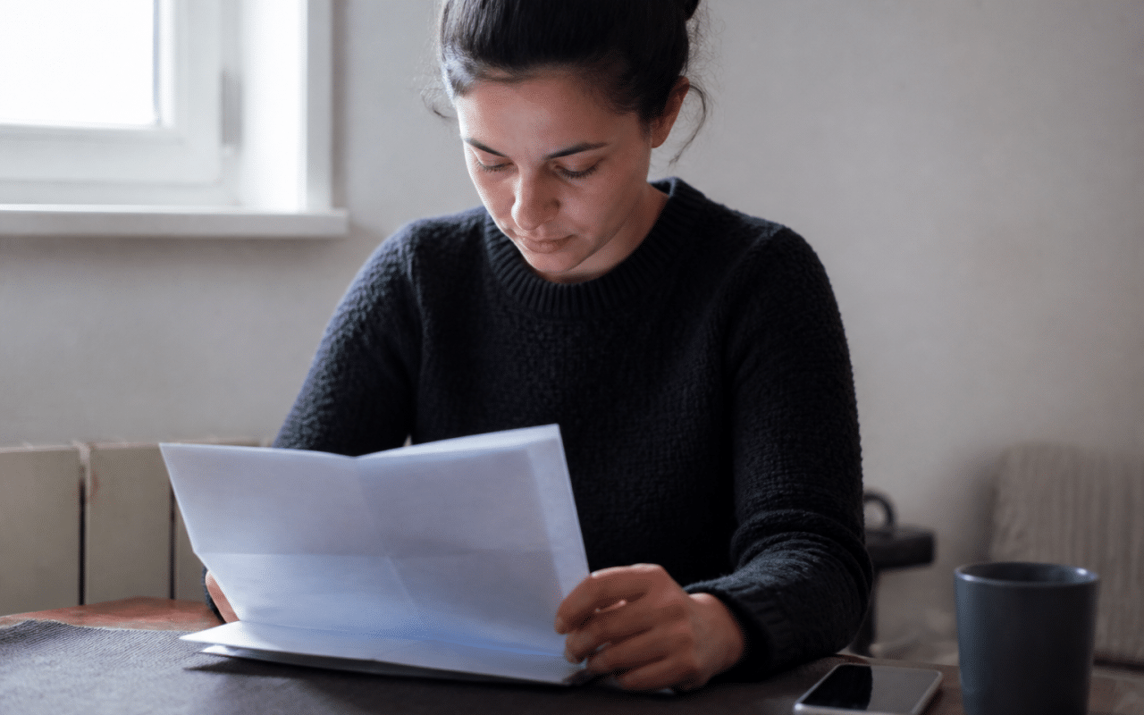 Personne consultant document administratif CAF sur table.