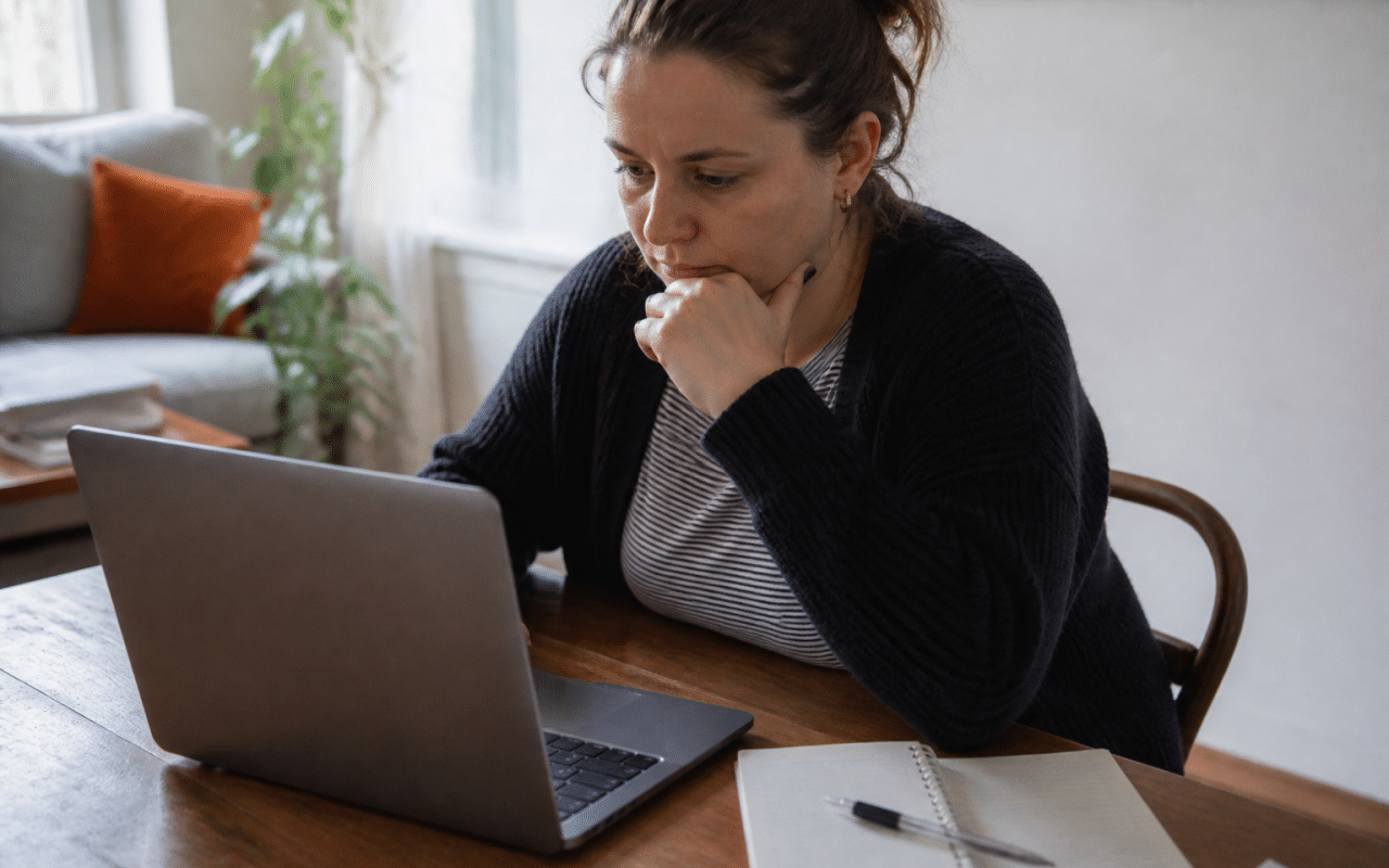 Personne consultant ordinateur portable pour calcul financier logement.