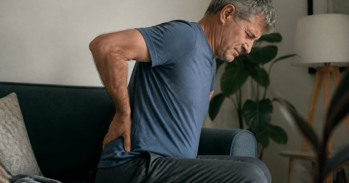 Personne assise tenant son bas du dos douloureux