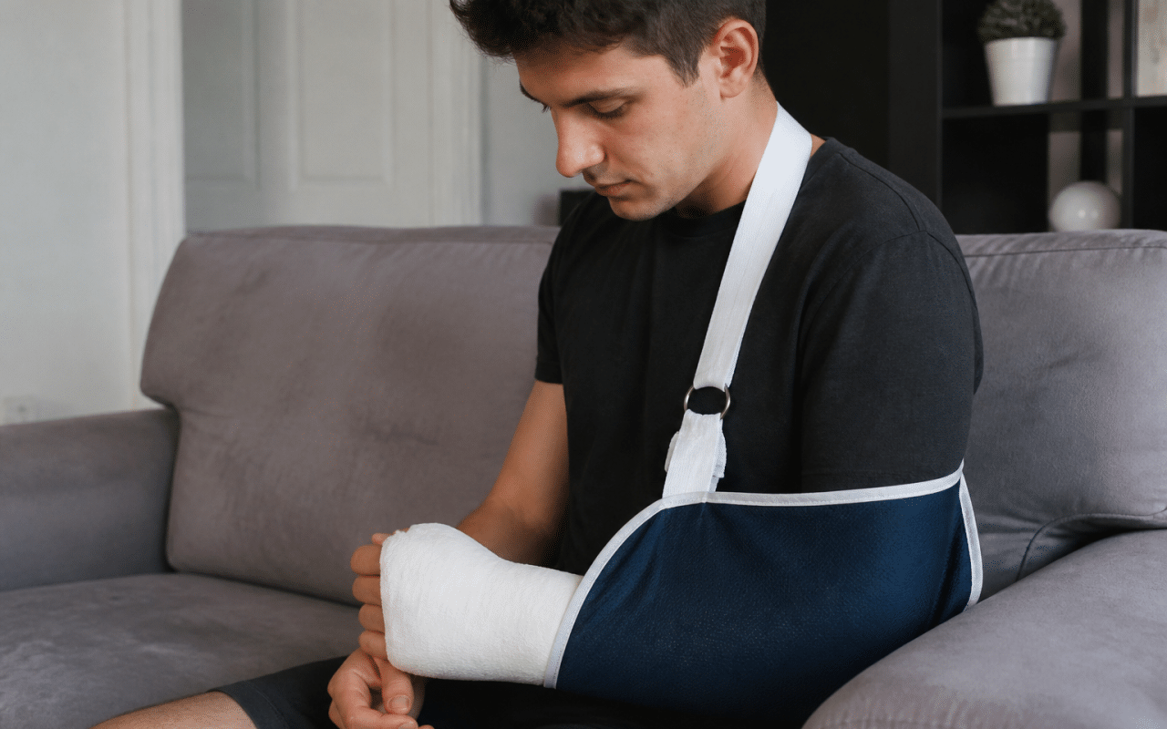 Personne immobilisee avec plâtre et écharpe de soutien.