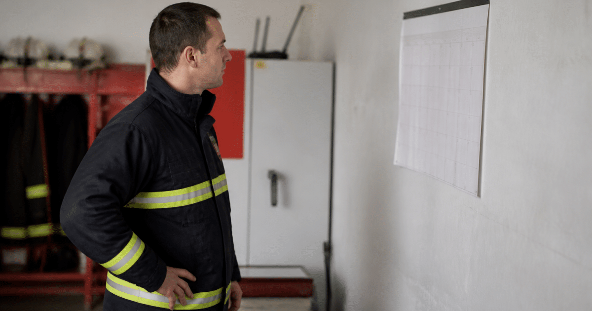 Pompier volontaire en tenue examinant calendrier mural