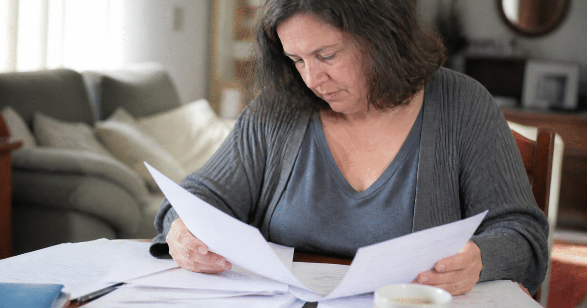 Personne consultant documents fiscaux avec formulaires d'impots etales
