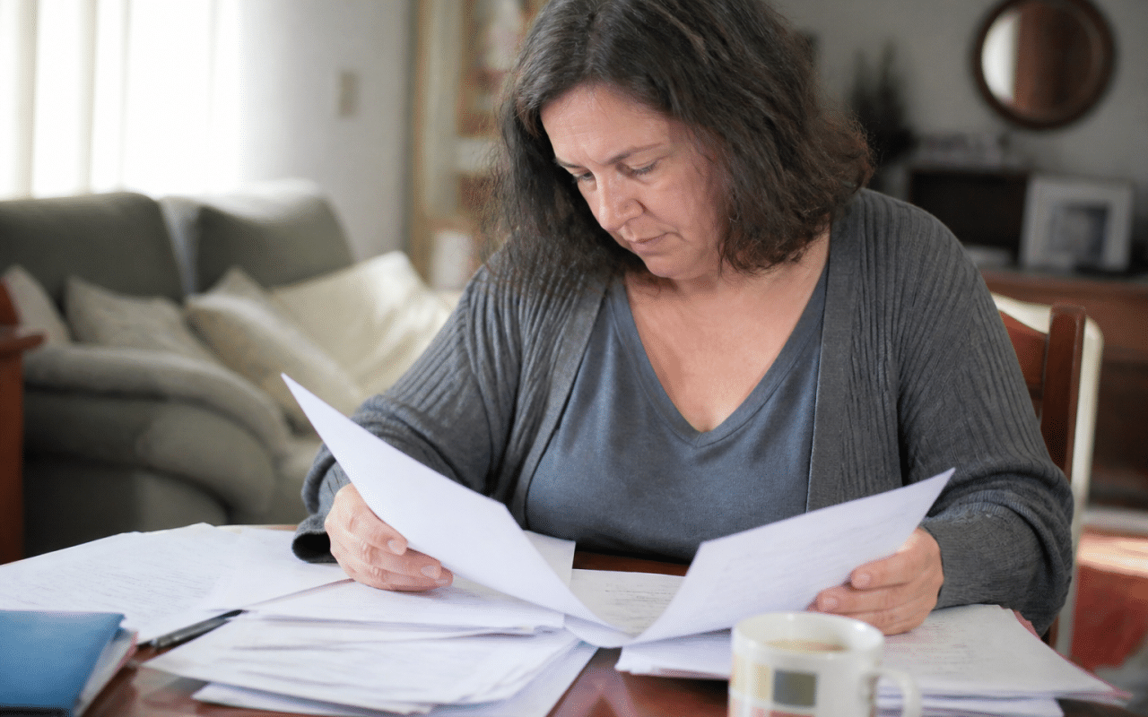 Personne consultant documents fiscaux avec formulaires d'impots etales