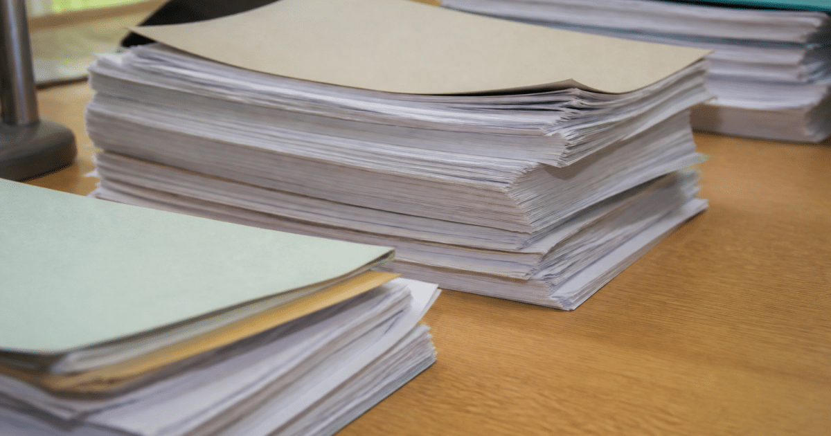 Documents officiels empiles sur bureau montrant statuts association