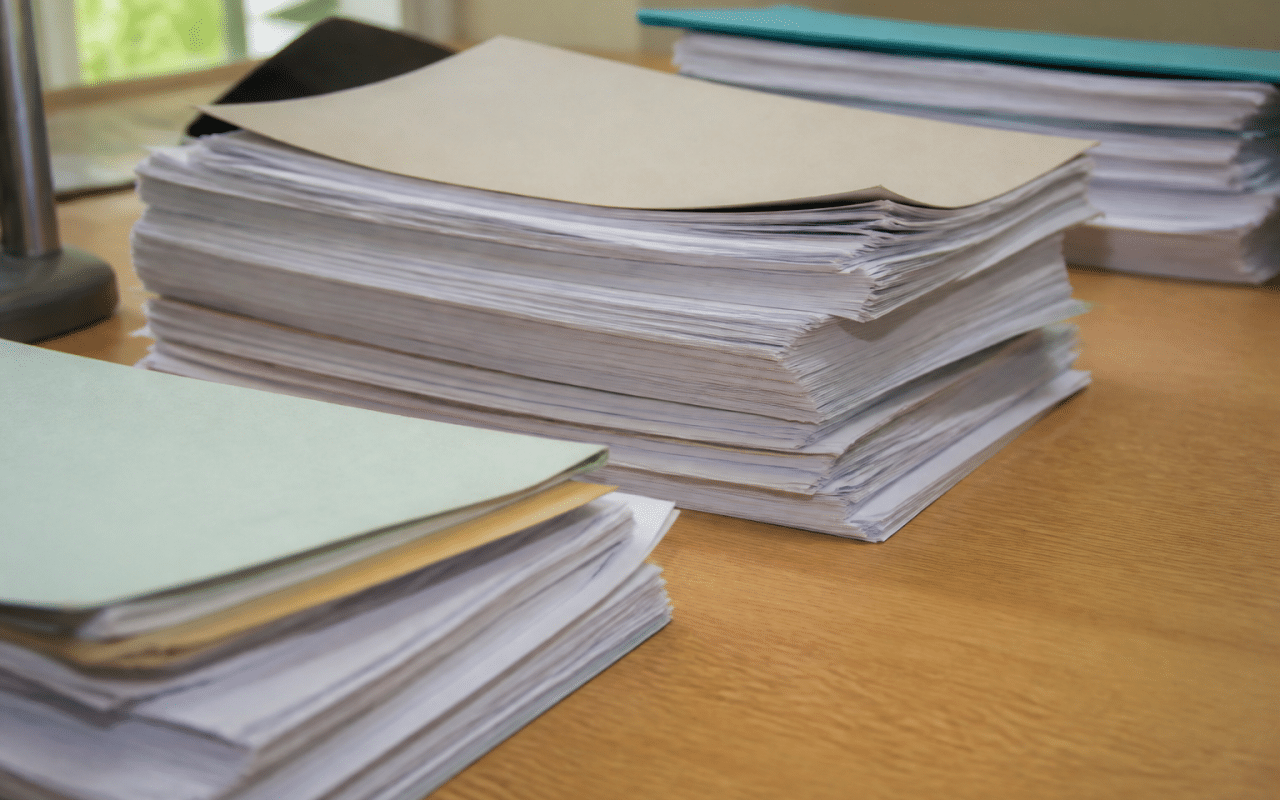 Documents officiels empiles sur bureau montrant statuts association