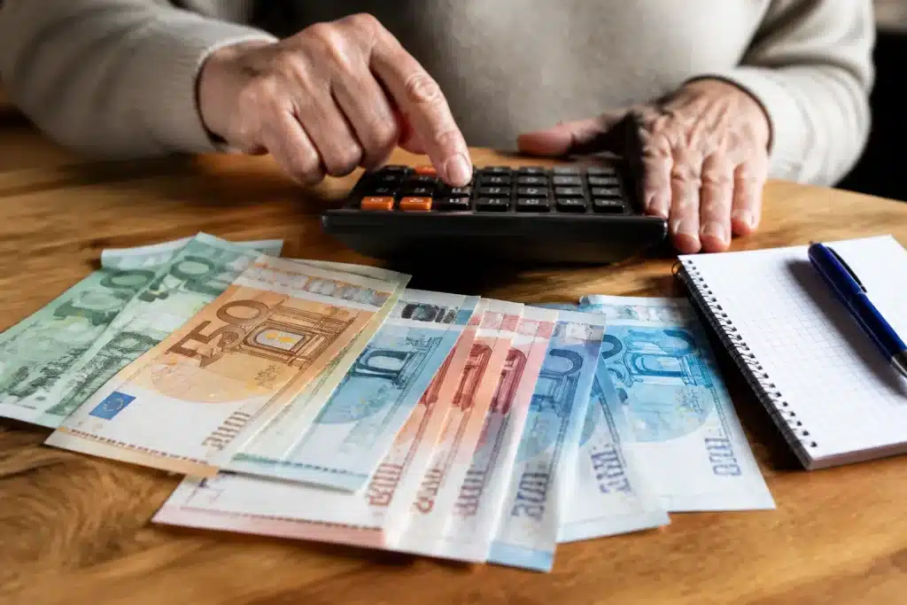 Billets euros et calculatrice montrant augmentation pension mensuelle