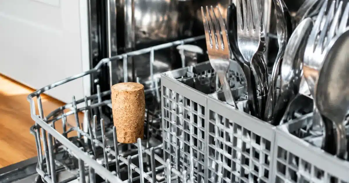 Bouchon liège posé verticalement panier couverts lave-vaisselle ouvert