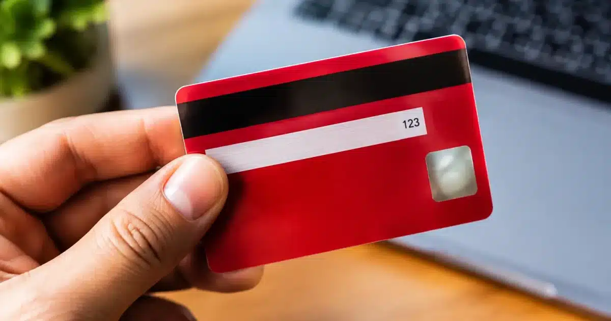 Carte bancaire rouge affichant trois chiffres visibles au dos