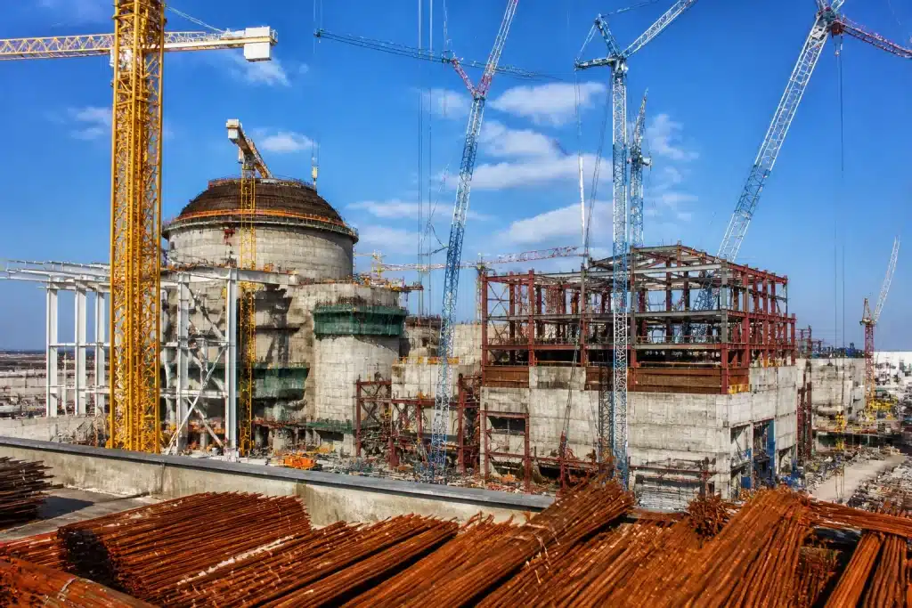Chantier nucléaire avec grues et structures métalliques inachevées