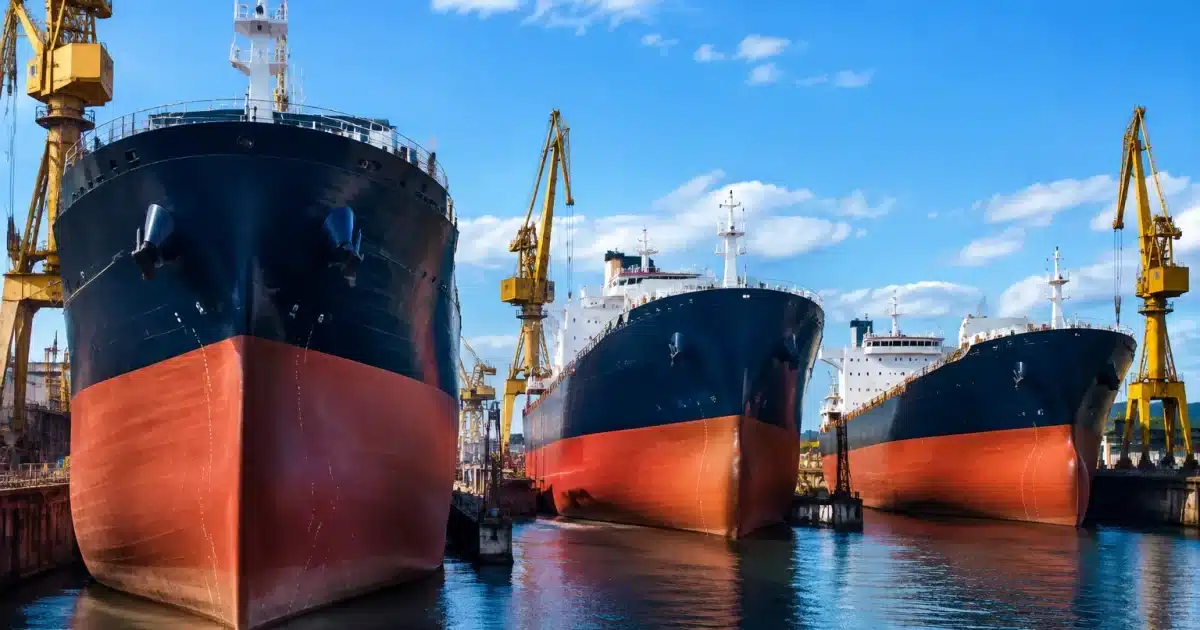 Trois navires géants alignés dans chantier naval moderne
