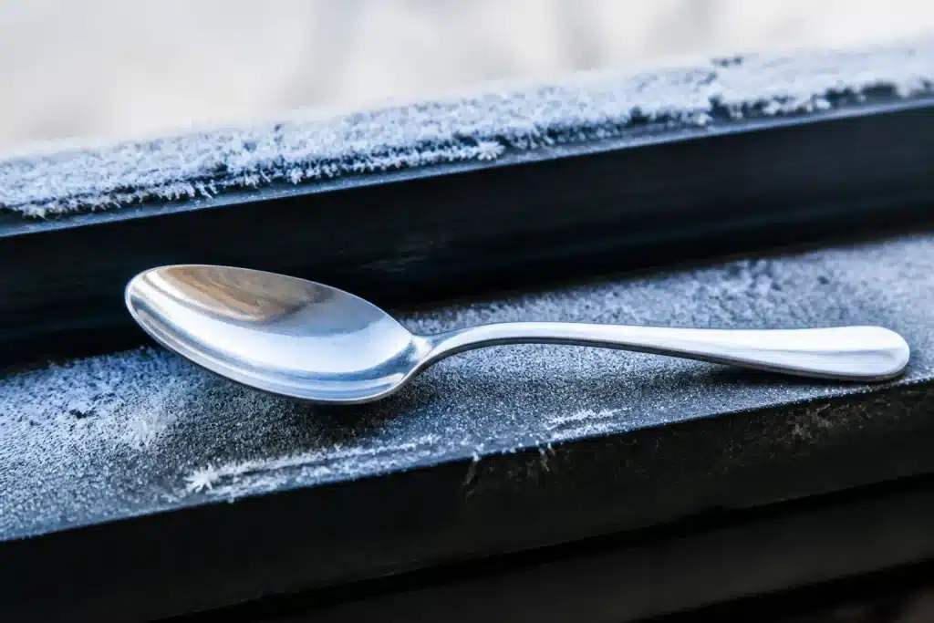 Cuillere metallique sur rebord fenetre givre