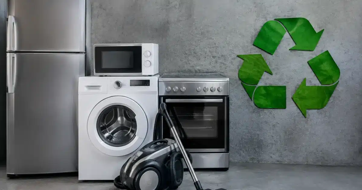 Electromenager ancien pose sur surface grise avec logo recyclage vert