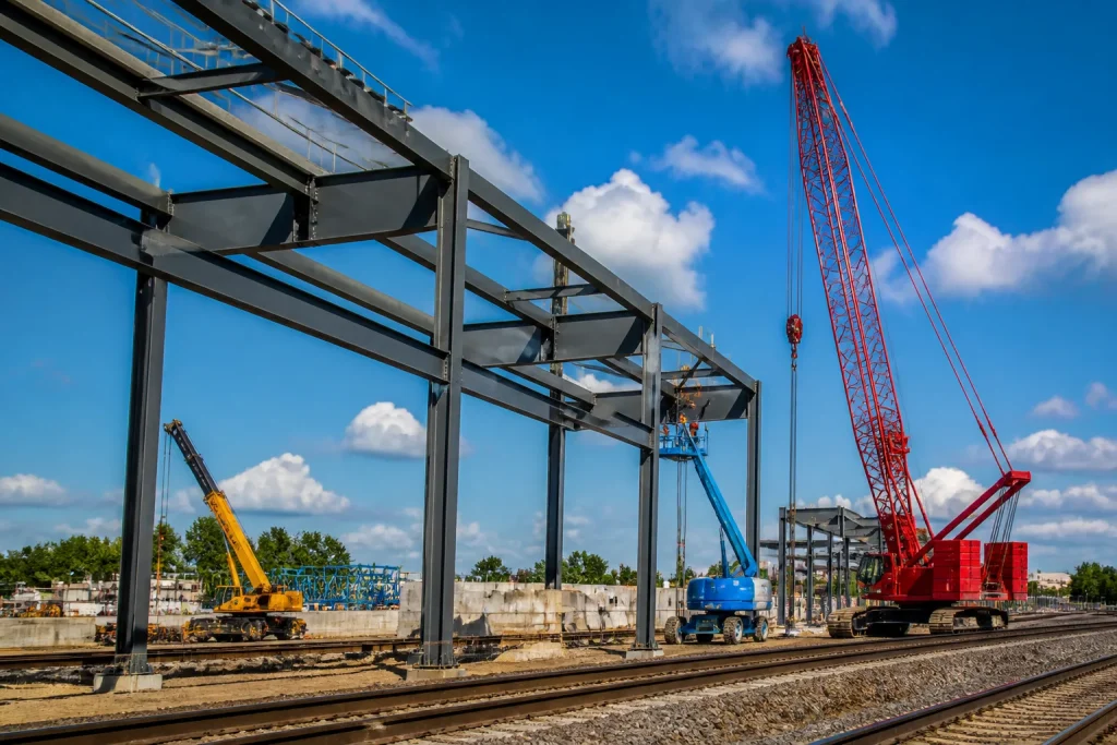 Infrastructure ferroviaire avec grues et structures acier