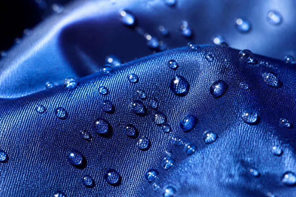 Gouttelettes eau formant perles tissu brillant hydrophobe