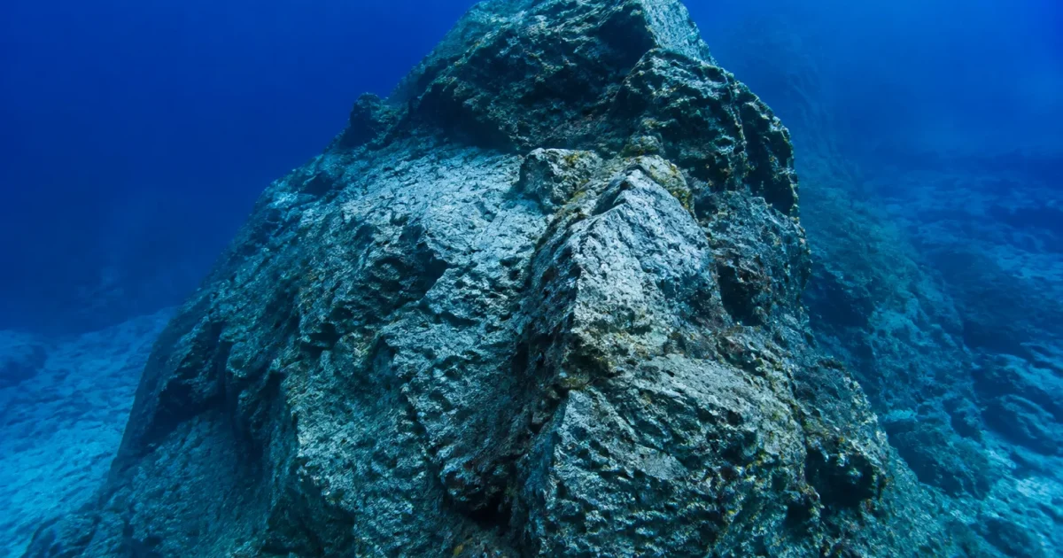 Monticule rocheux gris pose profondement sous l'eau froide oceanique