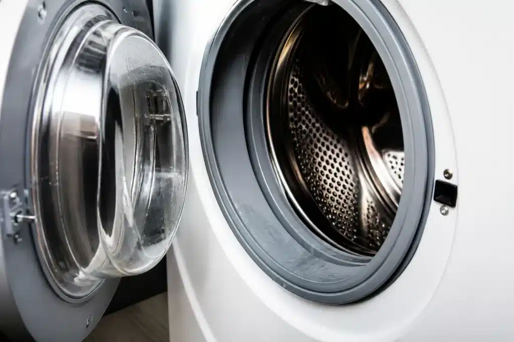 Porte de lave-linge ouverte avec joint humide visible