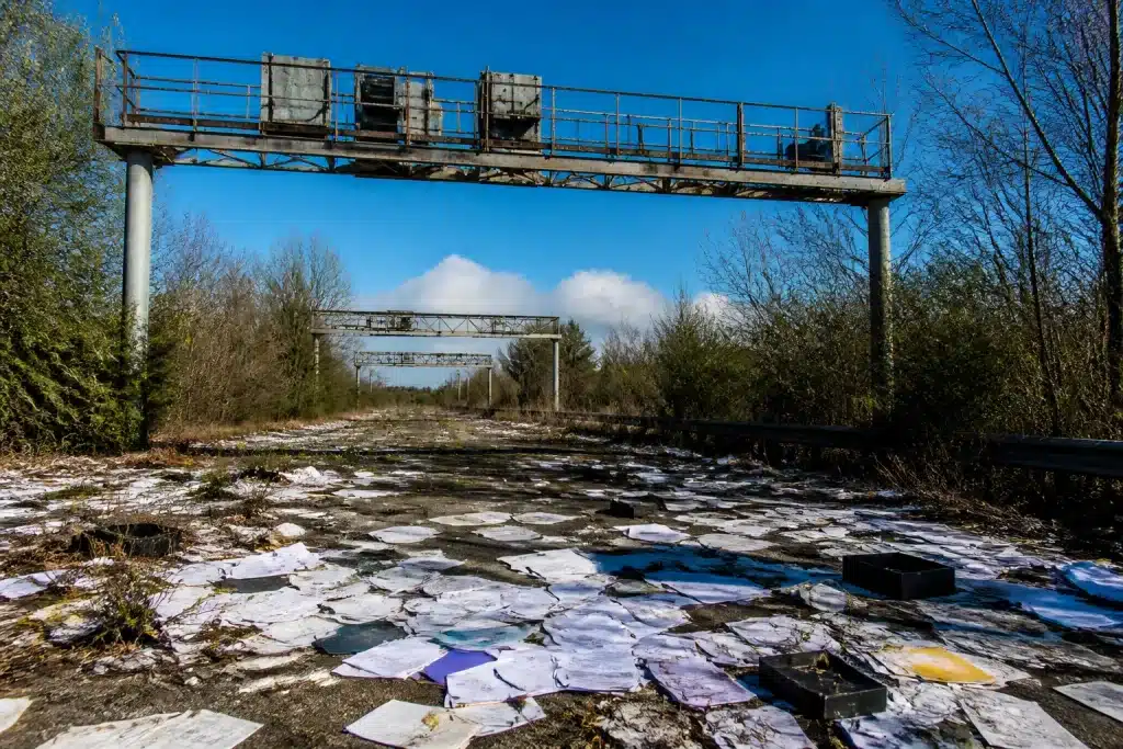 Portiques autoroutiers abandonnés avec documents financiers éparpillés