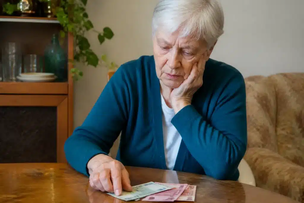 Personne agee comptant billets d'euros insuffisants sur table
