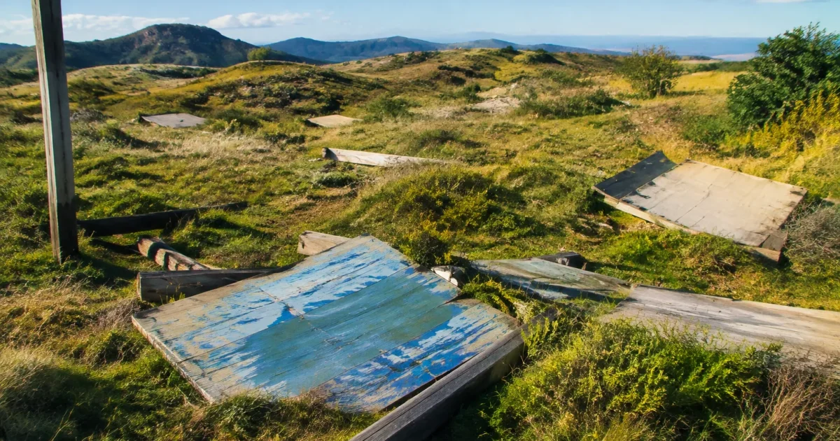 Terrain vague vallonné avec panneaux abandonnés éparpillés au sol