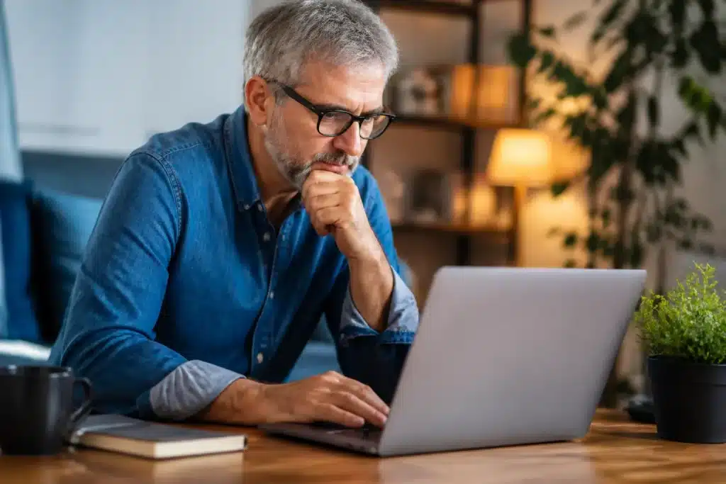 Personne consultant documents retraite sur ordinateur portable