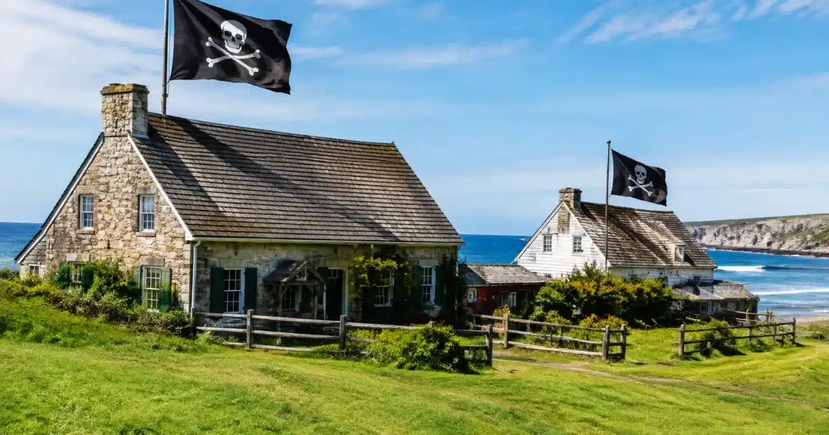 Bâtiments côtiers décorés de drapeaux pirates sur terrain verdoyant étendu